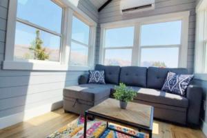 a living room with a blue couch and a table at Charming Tiny Home with private deck and bbq in Apple Valley