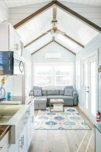 ein Wohnzimmer mit einem Sofa und einem Tisch in der Unterkunft Charming Tiny Home with private deck and bbq in Apple Valley
