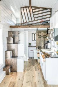 cocina con electrodomésticos blancos y suelo de madera en Charming Tiny Home with private deck and bbq en Apple Valley