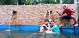 dos hombres y una mujer en el agua en Ella Residence Eco Resort, en Padukka