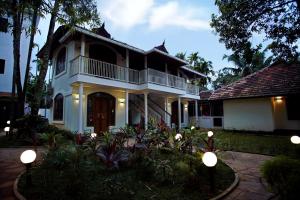 una casa blanca con luces delante en Bamboo Lagoon Backwater Front Resort, en Alleppey