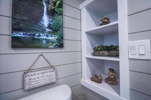 a bathroom with a toilet and a picture of a waterfall at Delightful tiny home conveniently located in Apple Valley