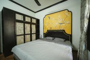 um quarto com uma cama grande e uma cabeceira amarela em Impresso Home & Cafe Hanoi em Hanói