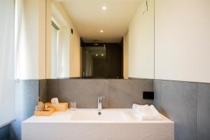 La salle de bains est pourvue d'un lavabo blanc et d'un miroir. dans l'établissement Bihotel, à Comerzo