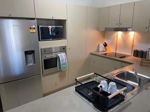 a kitchen with a sink and a dish drying rack at Lakeside Central Apartment in Townsville