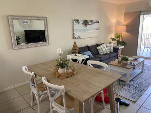 ein Wohnzimmer mit einem Tisch und einem Sofa in der Unterkunft Lakeside Central Apartment in Townsville