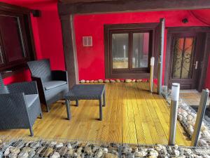 a room with two chairs and a red wall at L’Alsacienne room et spa in Lautenbach