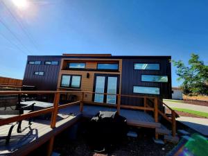 une maison modulaire avec une terrasse et une maison dans l'établissement Designer Modern Tiny Home w All of The Amenities, à Apple Valley