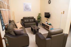 Una sala de estar con dos sofás y un televisor. en Adorable 3-bedroom home with Pool, Wi-Fi and BBQ, en Rembau