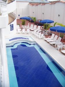 una piscina con sillas y sombrillas en un edificio en Hotel Zamba, en Girardot