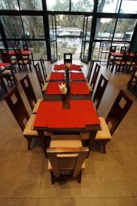 a dining room with a long table with red napkins at Bamboo Lagoon Backwater Front Resort in Alleppey