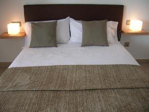 a large bed with two pillows and two lamps at Benicassim Lujo in Benicàssim