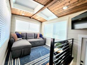 una pequeña sala de estar con sofá y TV en Peaceful Tiny Home with private deck-fire pit-bbq, en Apple Valley