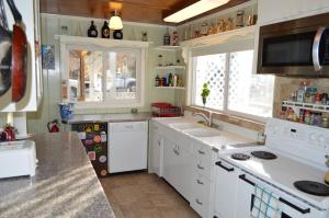 a kitchen with white cabinets and a sink and a window at The Hostel California in Bishop