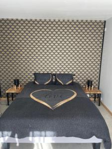Una cama con una manta negra con un corazón. en Gite La Dolce Vita en Les Ollières-sur-Eyrieux