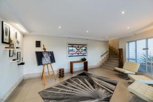 uma sala de estar com um quadro na parede e uma mesa em Villa Afrikana Guest Suites by Knysna Paradise Collection em Knysna