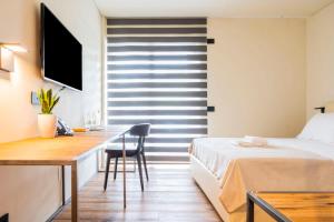 a bedroom with a bed and a desk and a bed and a television at Bihotel in Maiano