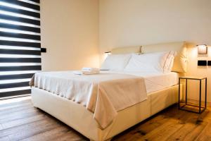 a bedroom with a large bed with white sheets and a window at Bihotel in Maiano