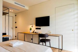 a room with a desk with a monitor on the wall at Bihotel in Maiano +76 photos