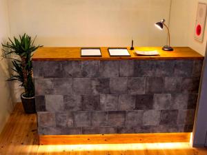 pared de piedra con escritorio en una habitación en 14 Guesthouse Mt.Fuji, en Fuji