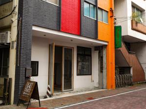 kolorowy budynek z znakiem przed nim w obiekcie 14 Guesthouse Mt.Fuji w mieście Fudżi