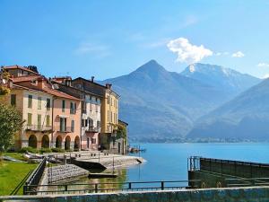 - une vue sur un lac avec des bâtiments et des montagnes dans l'établissement Appartamenti Il Castellaccio, à San Siro