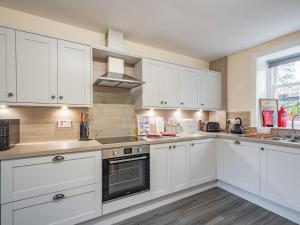 a kitchen with white cabinets and a stove top oven at Black Grouse in Culter