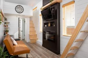uma sala de estar com uma escada e um relógio na parede em Modern Haven em Apple Valley
