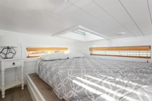 a large white bedroom with a bed and a window at Zion Tiny Home, Private Hot Tub, Near Trails in Apple Valley