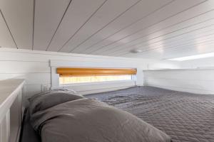 uma cama num pequeno quarto com uma janela em Modern Haven em Apple Valley