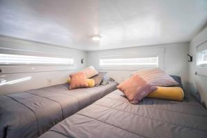 New modern & relaxing Tiny House w deck near ZION في Apple Valley: سريرين في غرفة صغيرة بها نافذتين