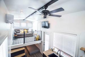 - un salon avec un ventilateur de plafond et un canapé dans l'établissement New modern & relaxing Tiny House w deck near ZION, à Apple Valley