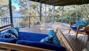 - une terrasse couverte avec un canapé et des chaises dans l'établissement Binnowee Lakeside - Between the ocean and lake, à Tiona