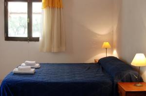 a bedroom with a blue bed with towels on it at Cabañas Donkaia in La Población