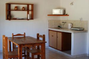 a kitchen with a wooden table and a table and chairs at Cabañas Donkaia in La Población