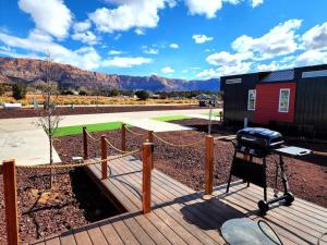 a grill on a wooden deck with mountains in the background at Romantic Tiny home with private deck in Apple Valley