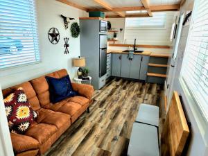 Apple Valley的住宿－Romantic Tiny home with private deck，一间客厅,客厅配有沙发,位于一个小房子里