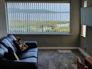 a living room with a couch and a large window at Dolphin Cottage in Grange Over Sands