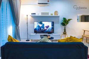 a living room with a blue couch and a tv at 1837 Guest House @ Kota Bharu, WiFi Netflix in Kota Bharu