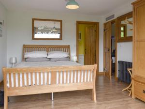 Hambleton的住宿－The Willows，一间卧室配有一张床和一张木凳