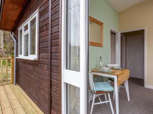 a room with a wooden door and a table with a chair at Kilninver - Uk31537 in Kirkhill