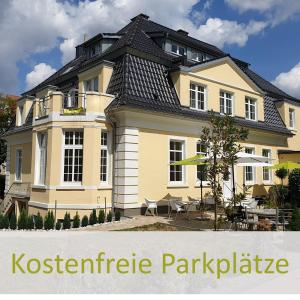 een groot geel huis met een zwart dak bij City Hotel ApartM3 am Park in Bad Oeynhausen