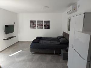 a white room with a bed and a tv at Villa Vered in Eilat