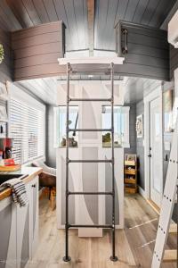 - une chambre avec une mezzanine dans une petite maison dans l'établissement Under The Sea Tiny Home, à Apple Valley