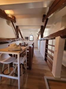ein Esszimmer mit einem Tisch, Stühlen und Holzbalken in der Unterkunft Cadre exceptionnel niché sous les toits dans le quartier historique in Albi