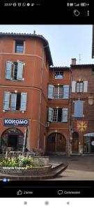 ein großes orangefarbenes Gebäude mit einem Brunnen davor in der Unterkunft Cadre exceptionnel niché sous les toits dans le quartier historique in Albi