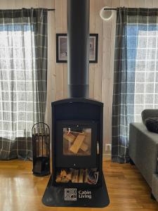 una stufa a legna in un soggiorno con divano di Family friendly cabin Hemsedal GolfAlpin golf, ski-out, fireplace & wifi a Hemsedal