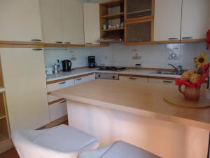 eine Küche mit weißen Schränken und einer Arbeitsplatte in der Unterkunft Apartment Take a Look in Dajla