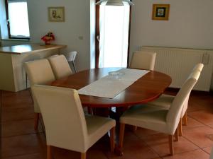 einen Esstisch mit weißen Stühlen um ihn herum in der Unterkunft Apartment Take a Look in Dajla