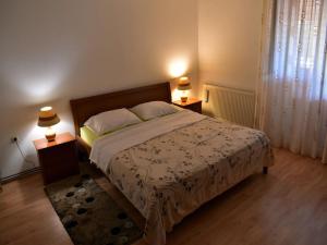 ein Schlafzimmer mit einem Bett mit zwei Nachttischen und zwei Lampen in der Unterkunft Apartment Take a Look in Dajla + 15 Fotos